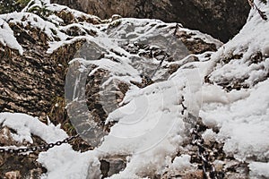 Snowy cliffs with chains for hiking