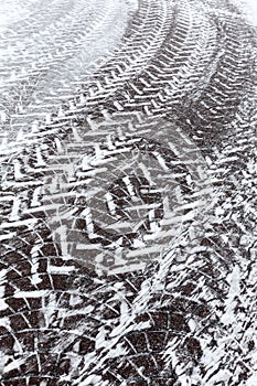 Snowy cobblestone road with tire tracks