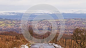 A snowy country road looking towards high, snow covered moors