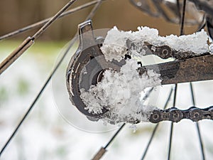 Snowy and dirty lubricated rear rail Derailleur. Detail of icy pulley of mountain bike