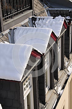 Snowy dormer windows at old building