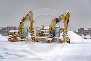 Snowy excavators during winter in Daybreak Utah