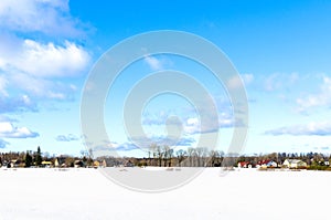 Snowy field against a village