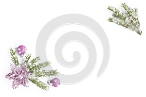 Snowy fir tree branch, pink glitter balls and flower or star on white background. Isolated. Top view with copy space. Flat lay.
