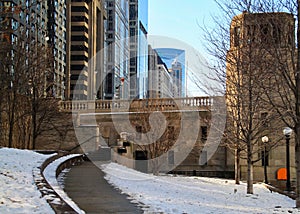 Snowy footpath bending away from the riverwalk in downtown Chicago Loop photo