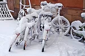 Snowy forgotten old bikes  on a winter February  street of an old European city