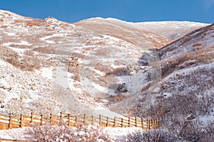 Snowy Hiking Trail Bordered by a Wooden Rail