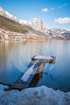 Snowy landing stage, jetty on lake Grundlsee with mountain Backenstein