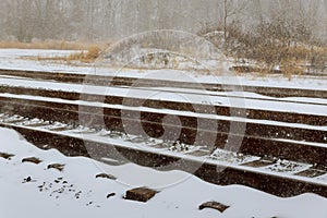 In a snowy landscape on a railroad in the winter, the rails are covered with snow