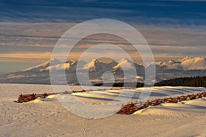 Snowy landscape with snow barriers at sunset