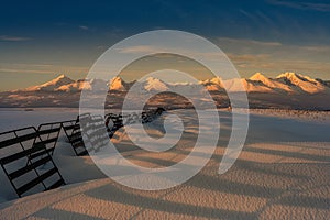 Snowy landscape with snow barriers at sunset