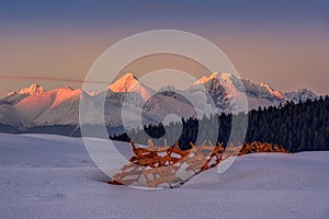 Snowy landscape with snow barriers at sunset