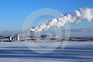 Snowy landscape with steaming coal power plant