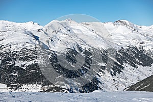 Snowy landscape with trees and high mountains in the mountain range of the Pyrenees, Andorra.