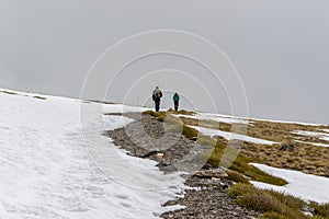 snowy landscape with two hikers walking in the background in Sierra Nevada photo