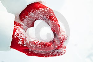 Snowy Love: Young Girl\'s Hands Holding Heart-Shaped Snow