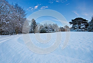 Snowy manor house grounds on a winter afternoon