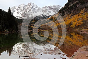 Maroon Bells reflected in the Maroon lake at sunrise in the Fall