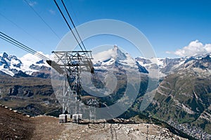 The snowy Matterhorn mountain in Switzerland in the foreground with a cable car column.