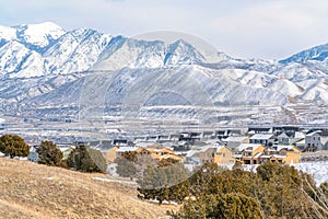 Snowy mountain and aerial view of houses in Utah Valley neighborhood in winter