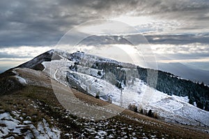 Snowy mountain landscape at sunset. The sun\'s rays break through the clouds. Alpe del Nevegal  Belluno  Italy