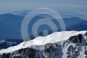 Snowy mountain lansdscape with mountain layers, ocean view in the background, Corsica, France