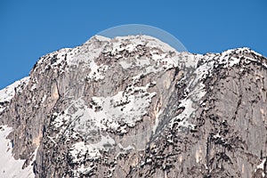 Snowy mountain peak Backenstein with summit cross on winter day