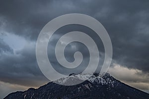 Snowy mountain peak dramatic gorgeous landscape wallpaper picturesque scenic view with cloudy gray sky background with sunset