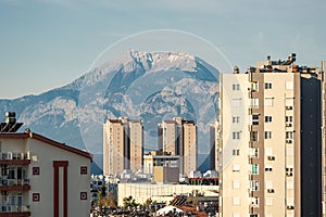 Snowy mountain peak visible through city buildings on a sunny day