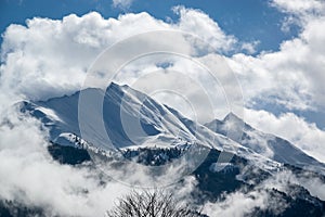 Snowy mountain peaks in Austria in the clouds.