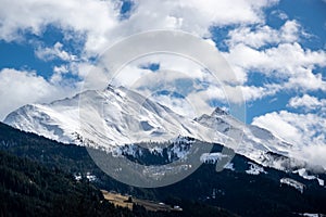 Snowy mountain peaks in Austria in the clouds.