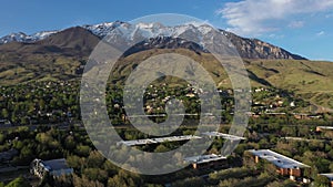 Snowy mountain in spring with neighborhoods and business park at its base