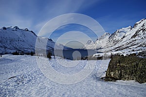 Snowy mountain with sunshine blue sky and fjord