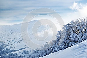 Snowy mountain top upon cloudy sky