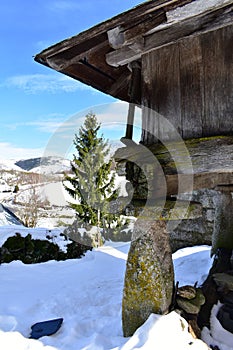 Snowy mountain village with galician granary horreo and fir tree. Piornedo, Lugo, Spain.