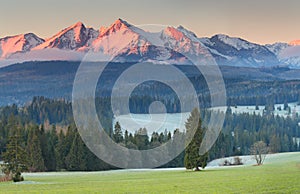 Snowy mountainpeaks in red sunligh