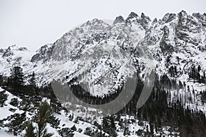 Snowy mountains and an impressive rock wall in High Tatra Mountains - the mountain range and national park in Slovakia