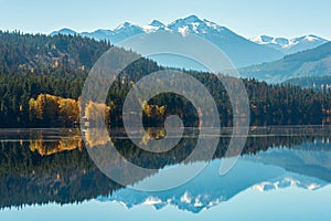 Snowy mountains reflected in Gun Lake in British Columbia, Canada