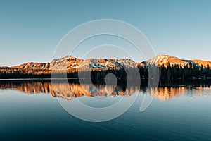 Snowy mountains reflecting in Mirror Lake, in the Uinta Mountains, Utah