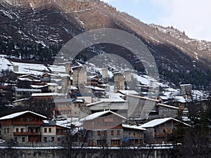 Snowy Old towers (Svan towers) and houses in the mountains, in winter. Mestia, Georgia