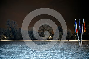 Snowy Park with Flagpoles at Night