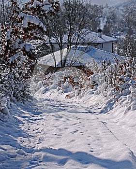 Snowy path and smoking chimney