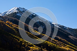 Snowy peak with changing leaves in Autumn photo