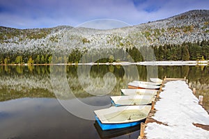 Snowy pier and boats on the lake,St Ana lake,Transylvania,Romania