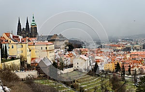 Snowy Prague City with gothic Castle from Hill Petrin