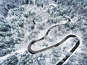 Snowy road in the forest. Extreme winding road high up in the mo