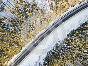 Snowy road with a moving car in winter
