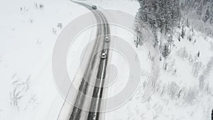 Snowy road runs through the forest in the mountains through the pass in December. The car rides through the winter snowy