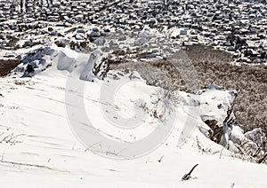 Snowy rocks, winter landscape and village