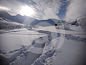 Snowy roof of a mountain cottage among the snowdrifts